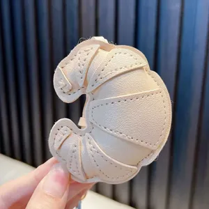 Handheld cream faux leather croissant bag charm with detailed stitching for keychains