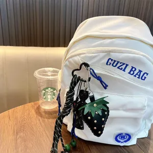 Stylish leather strawberry keychain with braided rope and tassel for bag decoration.