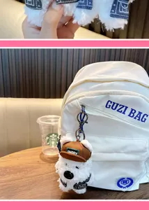 Détail d'un porte-clés en peluche West Highland Terrier avec une casquette marron