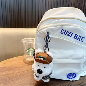 Adorable peluche de West Highland White Terrier avec casquette sur un sac à dos.