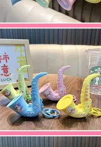 Detalle de mini llaveros de juguete con forma de saxofón en colores azul, rosa y amarillo