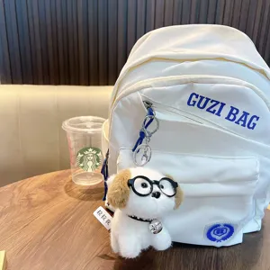 Schattige witte pluche honden sleutelhanger met bril op een minimalistische rugzak