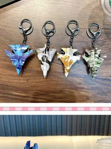 Dettaglio di portachiavi aereo da caccia mimetico in quattro colori militari su legno.