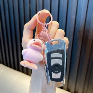 Fluffy pink flocked duckling keychain pendant held together with a silver car key fob in hand