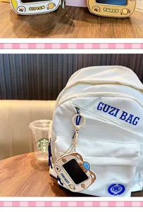 Close-up of cute kitten graffiti board keychain hanging on a white backpack