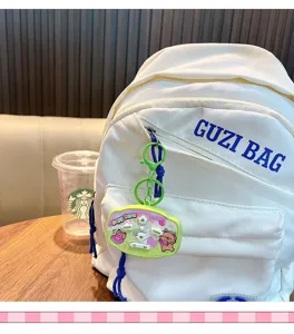 Capybara elektronisches Spiel Schlüsselanhänger Anhänger an einem stilvollen weißen Rucksack.