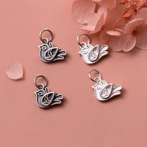 Macro shot of four vintage S925 silver bird charms for handmade jewelry making.