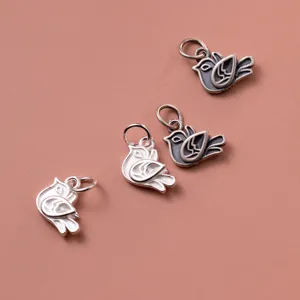 Close-up of S925 sterling silver bird charms with bright and antique Thai silver finishes