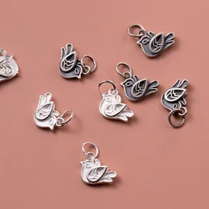 Macro detail showing vintage S925 sterling silver bird charms for handmade jewelry DIY.