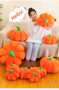 Multiple sizes of orange pumpkin plush pillows arranged around a person on a sofa
