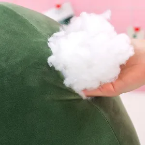 Primo piano del morbido ripieno di cotone bianco di un peluche di avocado verde.