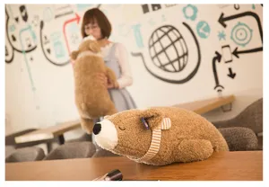 Vista dettagliata di un morbido peluche di orso polare marrone che dorme con sciarpa