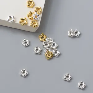 Primer plano de cuentas espaciadoras de flores de 5 mm en plata y oro para bisutería.