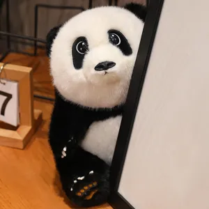 Realistic panda plush toy peeking from behind a white frame on wooden desk
