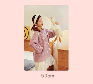 Modella con un morbido peluche a forma di oca bianca da 50 cm in camera da letto