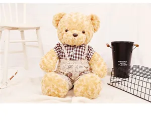 Orsetto di peluche vintage con camicia a scacchi e salopette in un ambiente interno