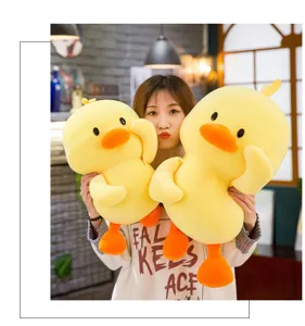 Large soft yellow duck plush toy pillow held by a girl in a cozy indoor setting