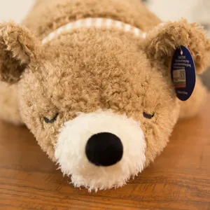 Morbido e soffice orso di peluche marrone che dorme con dettaglio sciarpa a quadri