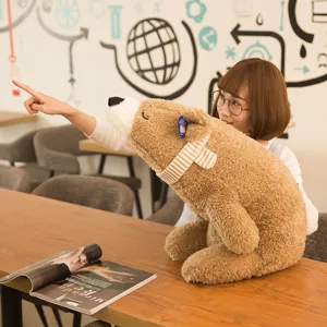 Grande peluche orso polare marrone con sciarpa a righe su tavolo legno