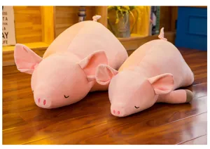 Zwei niedliche weiche rosa Schweine-Plüschtiere in verschiedenen Größen auf Holz Boden.