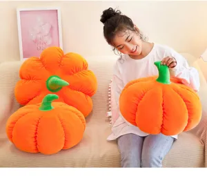 Soft orange pumpkin plush pillow held by a girl on a couch in a cozy home setting