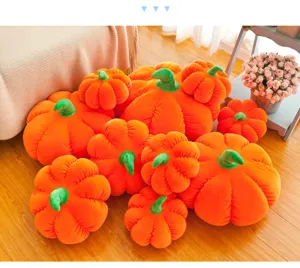 Macro view of various sized orange pumpkin plush pillows on a wooden floor.