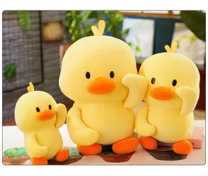 Three cute yellow duck plush toys in different sizes placed together on a decorative table.