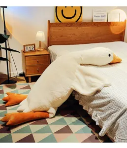 Cuscino di peluche a forma di oca bianca gigante in un accogliente ambiente da letto relax.