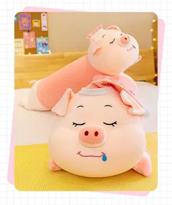 Close-up view of a soft pink sleepy pig plush toy pillow with a cute hat on a bed