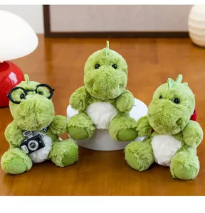 Vista detallada de tres dinosaurios de peluche verdes con cámara y gafas de juguete