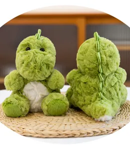 Primer plano del peluche de dinosaurio verde mostrando texturas delantera y trasera.