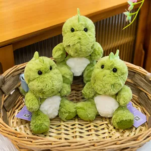 Set de tres lindos peluches de dinosaurio verde sentados en una cesta de mimbre natural
