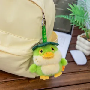 Adorable porte-clés canard en peluche vert suspendu à un sac à dos beige