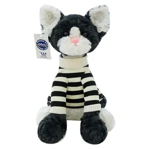 Adorable plush tuxedo cat wearing a black and white striped turtleneck sweater