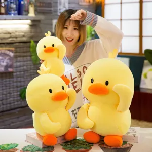 Three cute yellow duck plush toys in various sizes shown in a cozy indoor setting
