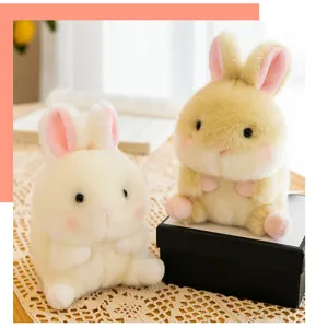 Grazioso ciondolo in peluche di coniglio sferico, consistenza morbida con orecchie rosa e dettaglio.