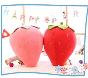 Coppia di graziosi cuscini di peluche fragola rossi e rosa in un ambiente festivo