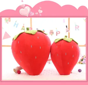 Vista dettagliata di due simpatici cuscini di peluche a forma di fragola rossa.
