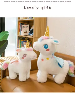 Dettaglio di due peluche a forma di unicorno bianco con corna dorate e criniera arcobaleno