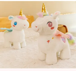 Dettaglio di due peluche a forma di unicorno bianco con corna dorate e code arcobaleno.