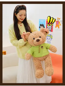 Adorable oso de peluche marrón con sudadera con capucha verde sostenido por modelo