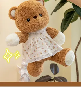 Nahaufnahme eines niedlichen braunen Teddybärs mit weißem Blumenkleid und Spitze für Kinder