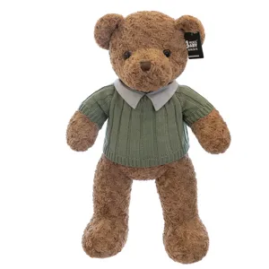 Simpatico orsetto di peluche marrone con maglione lavorato a maglia verde, morbido gioco.