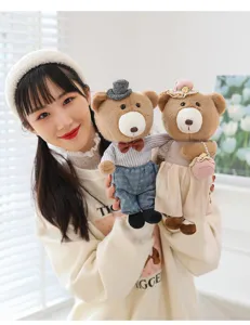 Close-up detail of cute plush teddy bear couple dolls wearing stylish miniature outfits