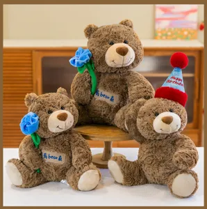 Tre orsetti di peluche marroni con fiori blu e un cappello rosso per il compleanno.