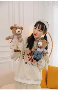 Detailed macro view showing a pair of adorable couple teddy bear plush toys with stylish outfits
