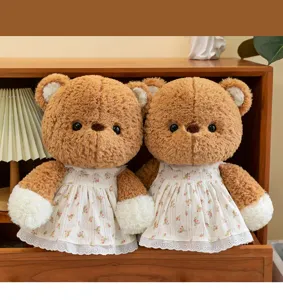 Zwei niedliche braune Teddybären mit vintage Blumenkleidern in einem gemütlichen Holzschrank