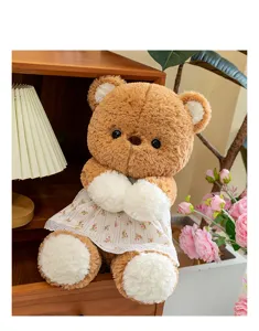 Nahaufnahme eines süßen braunen Teddybär-Plüschtiers in einem weißen Blumenkleid zu Hause