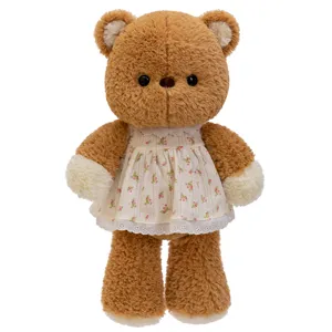 Plüschiger brauner Teddybär in floralem weißem Kleid, ideales Waldtiergeschenk für Kinder.