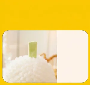 Dettaglio macro del morbido tessuto sherpa bianco e gambo verde del peluche a forma di frutto